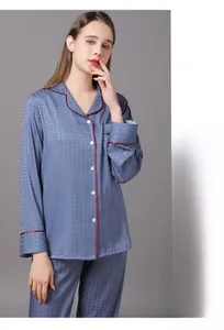 Detail of blue silk pajamas with houndstooth pattern and red piped V-neck collar