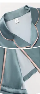 Détail du col et de l'ourlet du pyjama en soie avec liseré rose et tissu vert gris