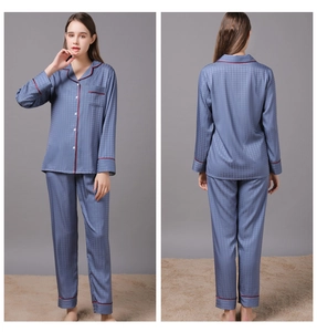 Close-up of blue silk pajama set featuring houndstooth pattern and red piping detail
