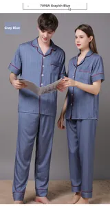 Detail of grayish blue houndstooth pajamas with contrast red piping and buttoned collar