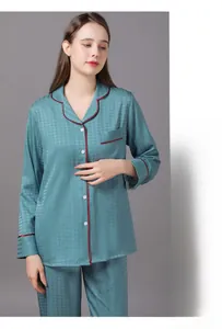 Close-up of blue satin pajama set featuring houndstooth jacquard and red piped edges