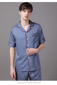 Detail of light blue satin pajama set for men with houndstooth pattern and red piping edges