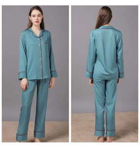 Detail of teal satin pajamas showing houndstooth texture and contrast piping details