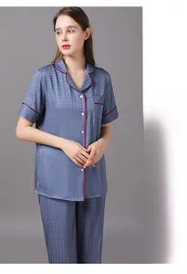 Detail of blue silk pajamas featuring red contrast piping and a subtle houndstooth texture