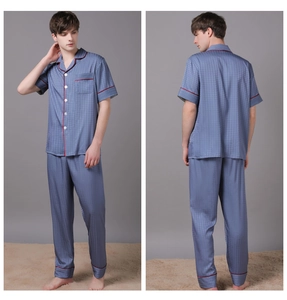 Detail of men's navy blue silk pajamas with houndstooth texture and red piping trim