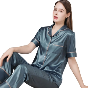 Ensemble pyjama femme en satin bleu avec manches courtes et pantalon sur fond blanc