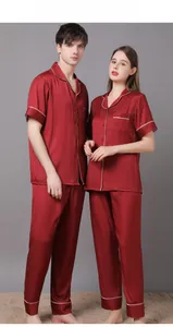 Detail of red silk pajama set showing contrast piping and smooth satin texture