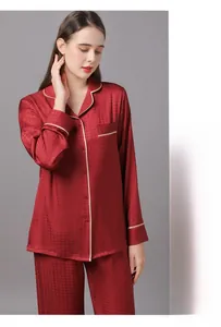 Detail view of red satin pajamas with houndstooth texture and white piping trim
