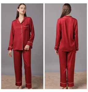 Detail view of red satin pajamas with houndstooth texture and white piping trim details