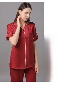 Detail of red houndstooth satin pajamas set featuring white piping and high-end texture