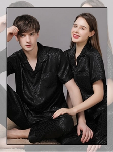 Close-up of black satin pajama set with subtle leopard print and silk-like texture