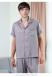 Detail of men's short-sleeve satin pajamas set featuring red contrast piping and vertical stripes