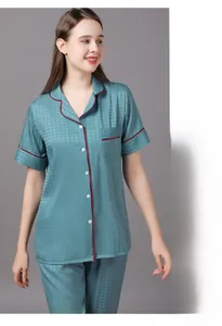 Detail of teal women's pajama set with houndstooth texture and red contrast piping