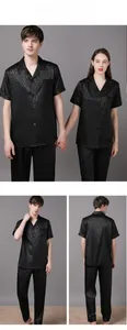 Detail of couple's black leopard jacquard satin pajamas with silk-like glossy finish