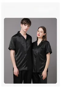 Detail of couple's black satin loungewear featuring subtle leopard jacquard patterns