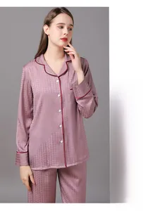 Detail of dusty rose silk pajamas showing houndstooth texture and crimson piping detail