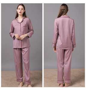 Close-up of silk pajamas set in mauve with houndstooth texture and red piping detail