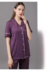 Detail of purple satin pajama set featuring white piping and high quality textured fabric