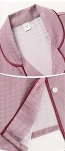 Detail of pink silk pajamas featuring houndstooth pattern and burgundy piping