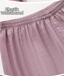 Detail of lavender silk pajamas showing the elastic waistband and jacquard fabric texture