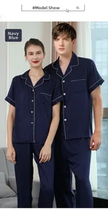 Detail of navy blue striped silk pajama set featuring white piping and chest pocket