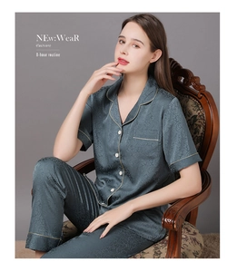 Détail d'un pyjama en satin bleu-gris avec texture jacquard florale et passepoils