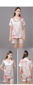 Detailed view of women's silk satin pajamas set with floral print and green piping edges