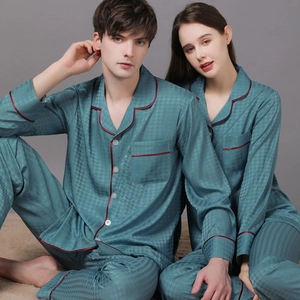 Matching teal silk pajama set with houndstooth texture and red piping for couples