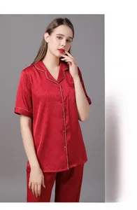 Détail du pyjama en satin rouge montrant le motif jacquard et les passepoils blancs