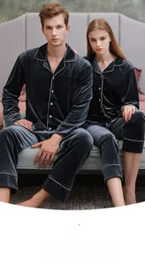 Detail of dark blue velvet couple pajamas showing the soft texture and white piping trim
