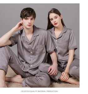 Détail de pyjamas en soie pour couple avec motif damas et liserés dorés contrastés