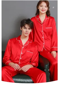 Detail of red silk satin pajamas with white piping and buttons for couples