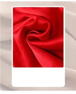 Macro shot of red silk satin fabric texture showing smooth glossy luster and soft folds
