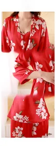 Detail view of red floral silk satin pajamas showing neckline, cuffs and hem finishing