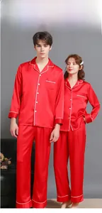 Detailed view of red silk pajama set with white piping and classic button-up design
