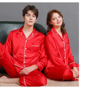 Detail of red satin couple pajamas featuring elegant white contrast piping and button-up front