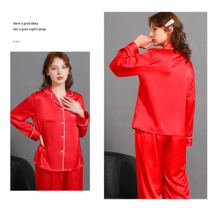 Detail of red silk satin pajamas featuring white piping and classic lapel collar set