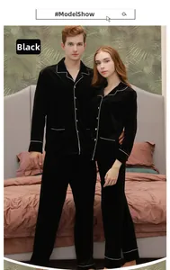 Matching black velvet pajamas set with white piping trim shown in a cozy bedroom setting