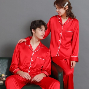 Matching red silk satin pajama set for couples with white piping and long sleeves