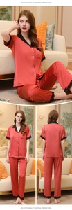 Detail of red silk satin pajama set with black lace trim and white buttons on the cuffs