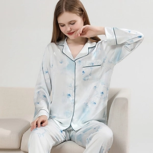 Women's floral silk pajama set featuring long-sleeved button-down top and matching pants