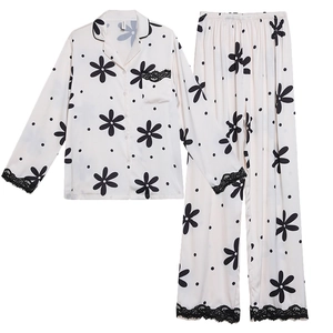 Women's silk pajama set with floral print, long sleeves, and black lace trim on white fabric