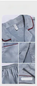 Detail view of light blue silk pajamas featuring maple jacquard patterns and red piping trim