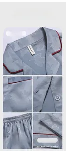 Detail of light blue silk pajamas showing leaf jacquard texture and red piping trim