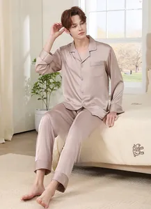 Detail of luxury champagne silk pajamas featuring classic lapels and grey piping details