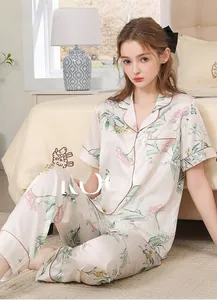 Silky floral pajama set with short sleeve top and long pants in a cozy bedroom setting