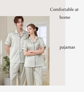Detail of sage green silk pajama sets with contrast piping for couples in home setting