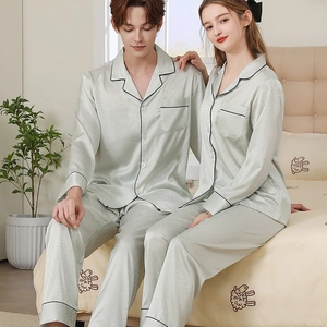 Matching couple silk pajama set in light sage green with black contrast piping detail