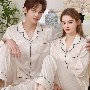 Matching beige silk pajama sets for couples with stylish black piping and wavy texture