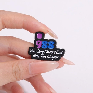 Detail of enamel pin with 988 digits and Your Story Doesn't End With This Chapter text